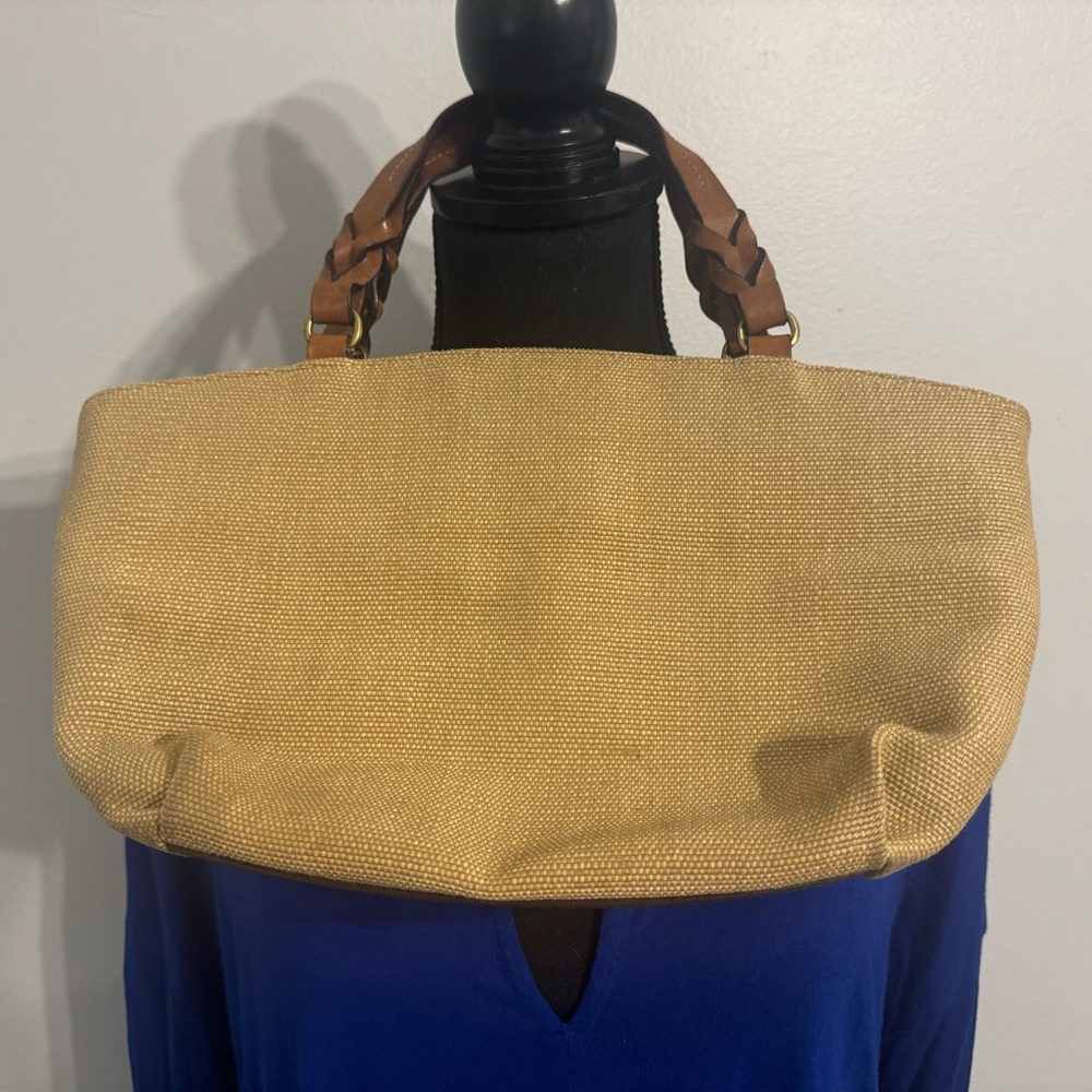 Tan canvas purse with short braided handles.